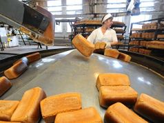Работница укладывает хлеб в лотки в цехе готовой продукции ОАО 