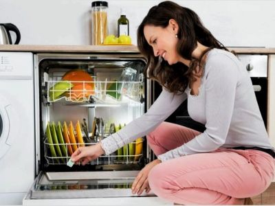 Женщина пользуется посудомоечной машиной. Фото: Depositphotos